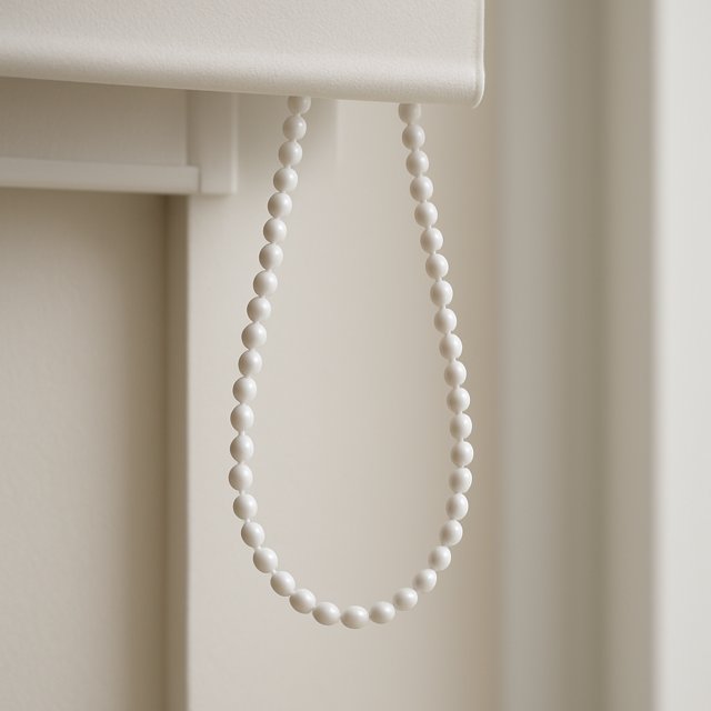 Close-up of a looped beaded chain mechanism on a roller shade